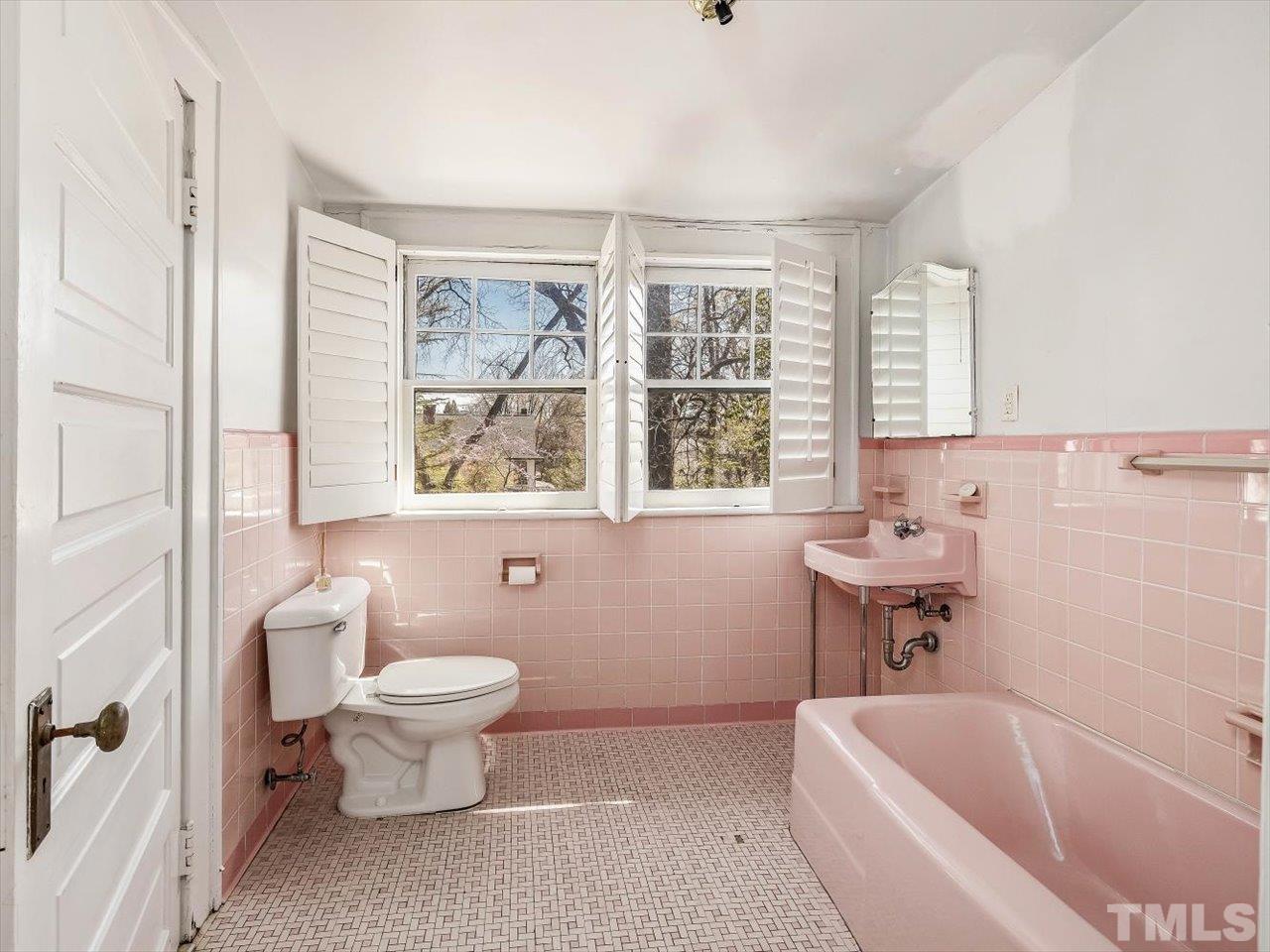 118 Hawthorne Road Raleigh, NC 27605 - Photo 32 of 42 a bath room with a toilet a bath tub and a window