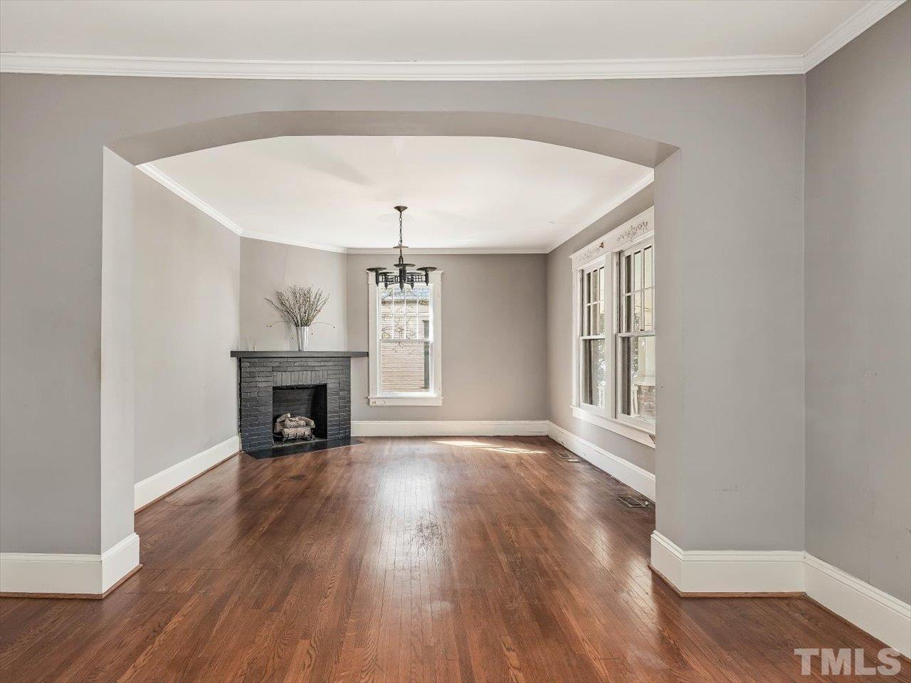 118 Hawthorne Road Raleigh, NC 27605 - Photo 9 of 42 a view of an empty room with wooden floor fireplace and a window