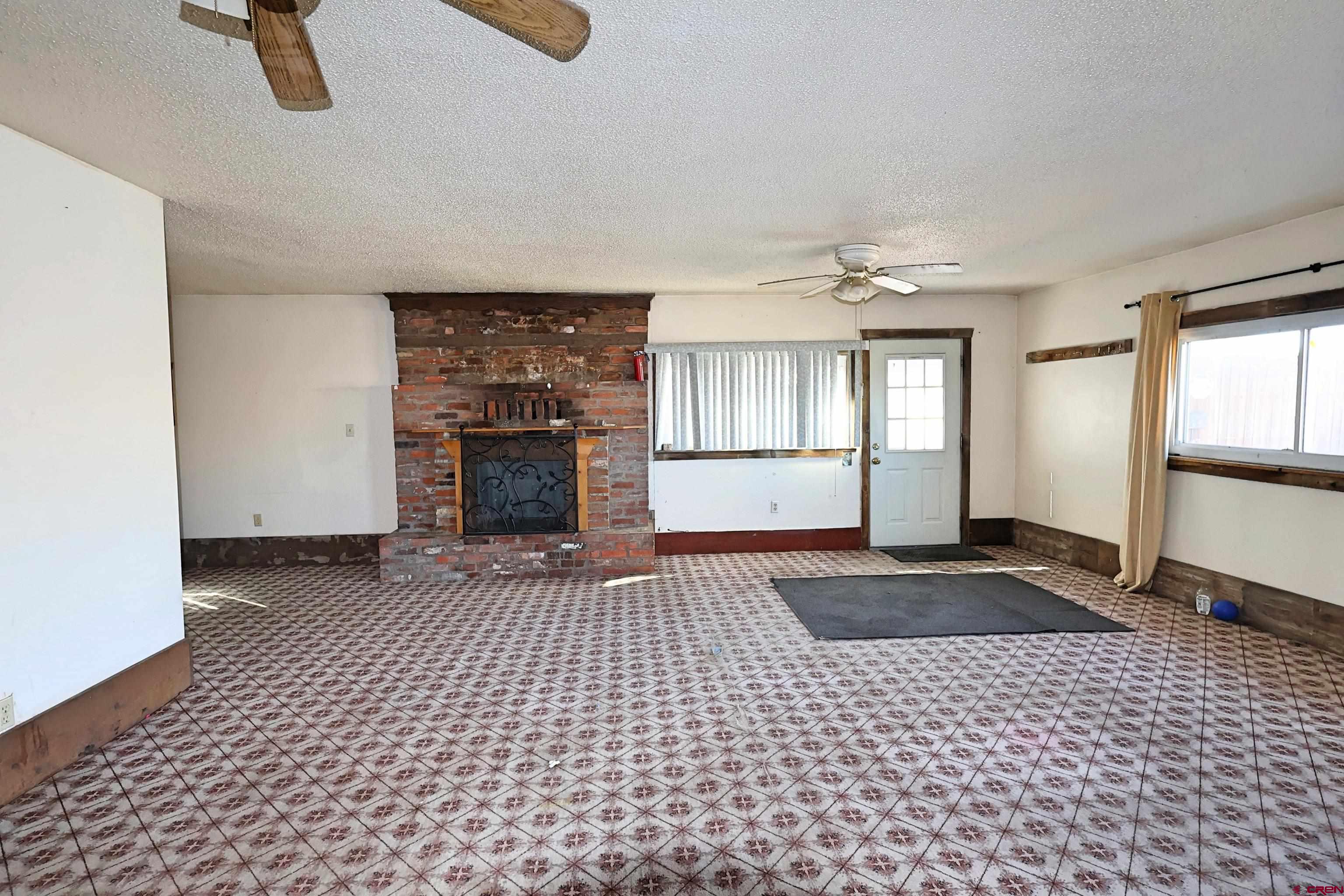 730 8th Street Alamosa, CO 81101 - Photo 3 of 29 a view of a livingroom with a fireplace window and wooden floor