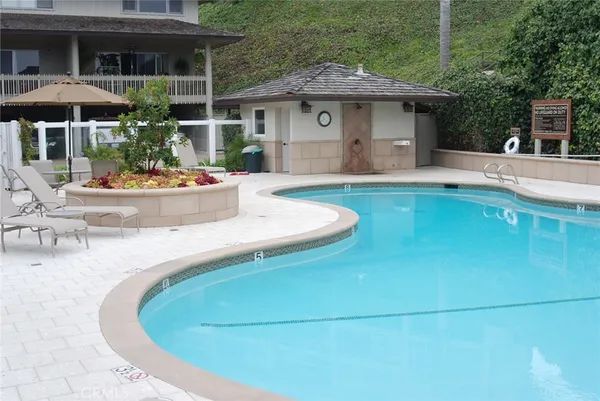 a view of a house with pool fire pit and chairs