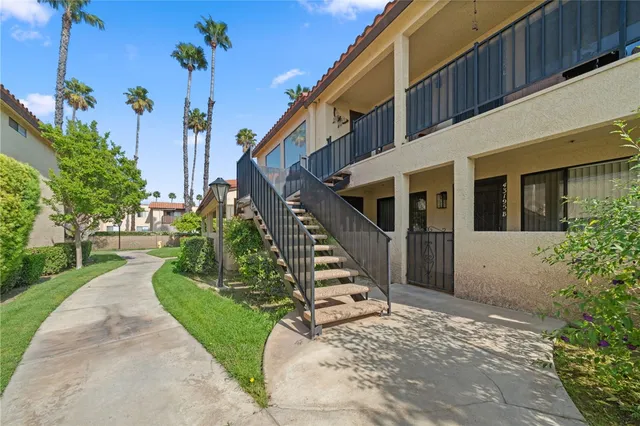 a view of a house with a small yard and potted plants