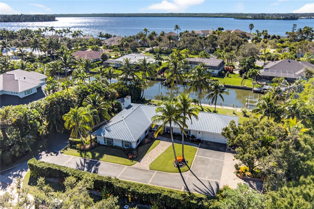 an aerial view of a house with a yard and lake view