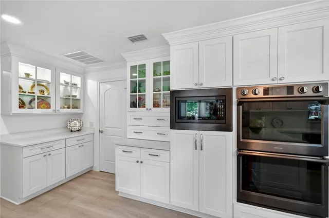 a kitchen with white cabinets and appliances