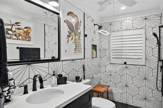 a bathroom with a sink vanity mirror and toilet