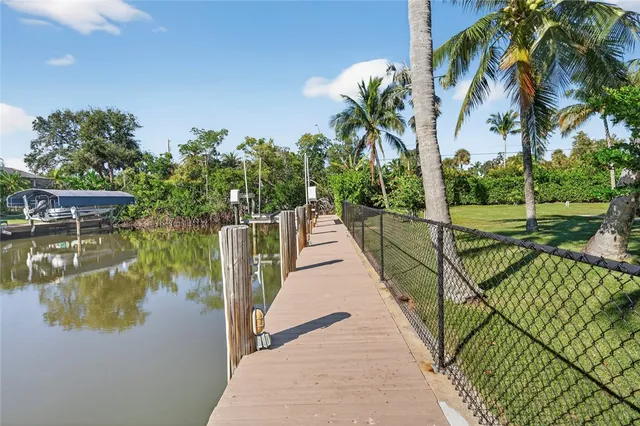 a view of a lake with a floor to ceiling window next to a yard