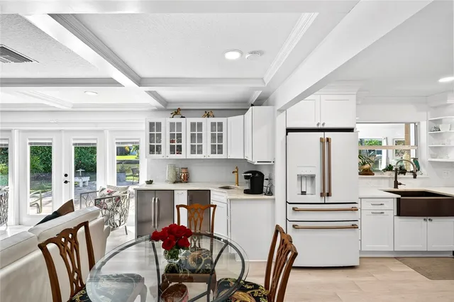 a kitchen with stainless steel appliances a refrigerator a table and chairs