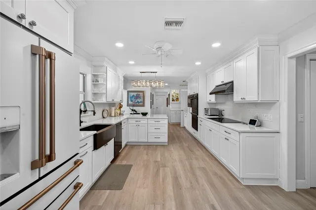 a large kitchen with stainless steel appliances lots of counter space and wooden floors