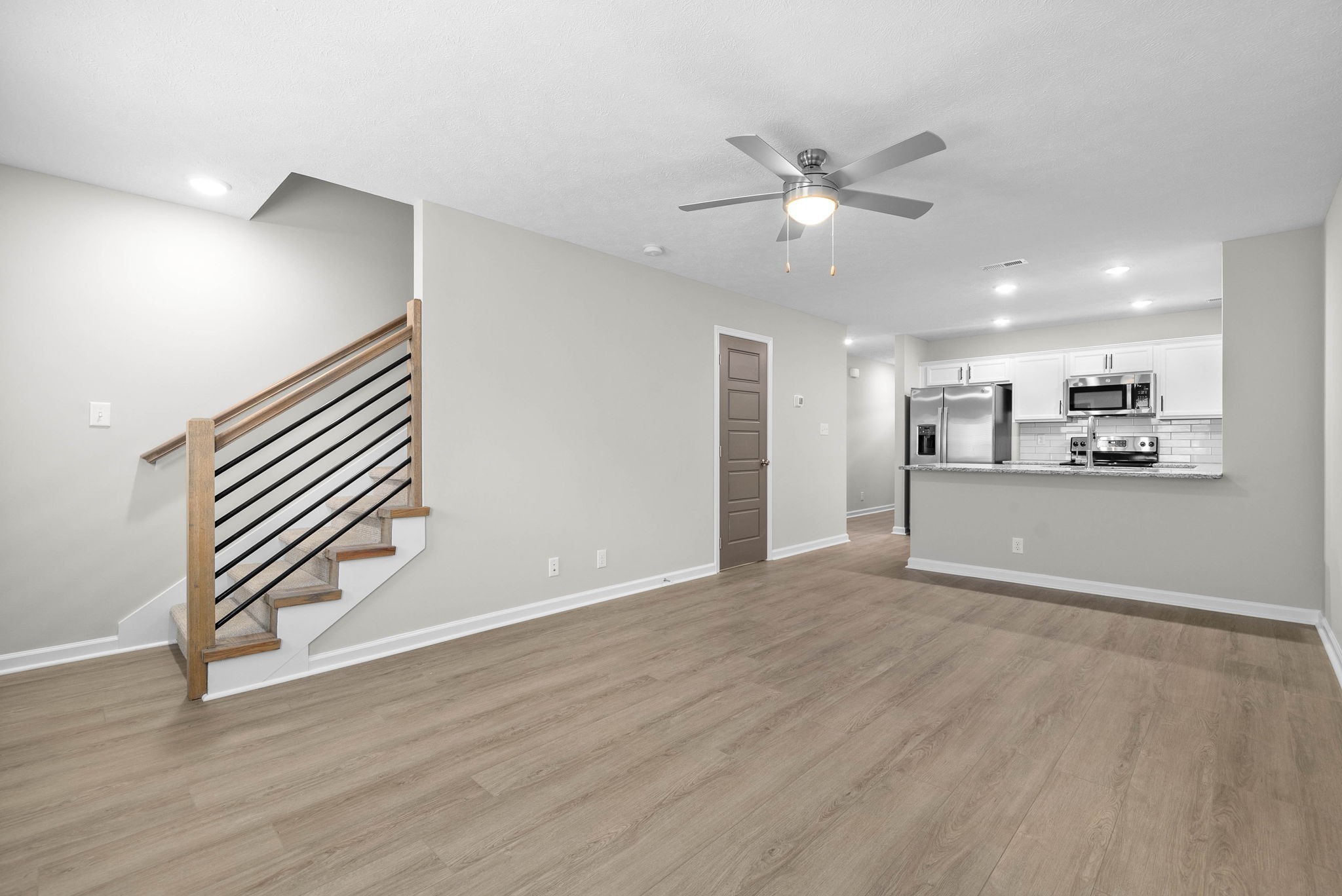 301 Longshadow Trail, Unit B Clarksville, TN 37043 - Photo 10 of 29 a view of an empty room with wooden floor and a ceiling fan