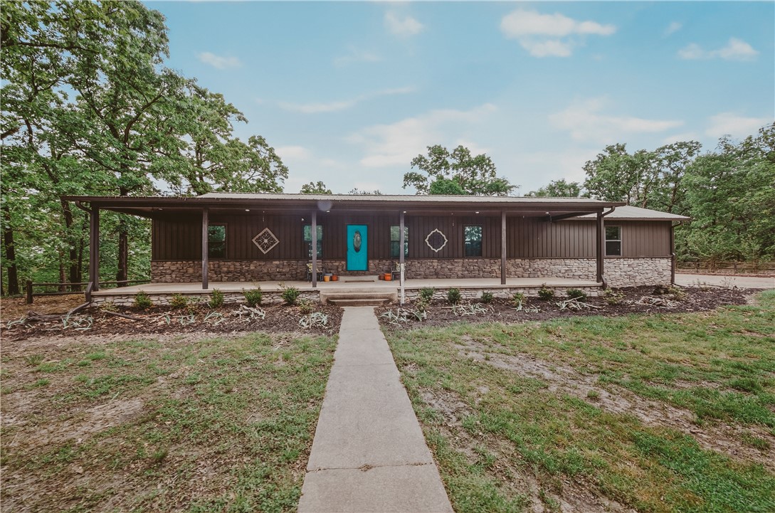 648 Dequeen Lake Road De Queen, AR 71832 - Photo 33 of 46 This home features an inviting front porch with stone accents and a vibrant turquoise entry door