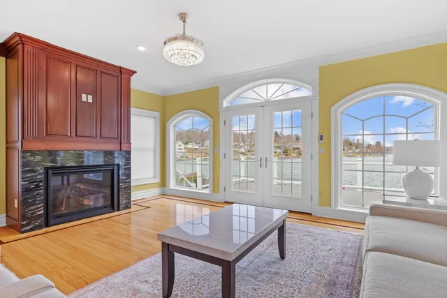 a living room with furniture a fireplace and a floor to ceiling window