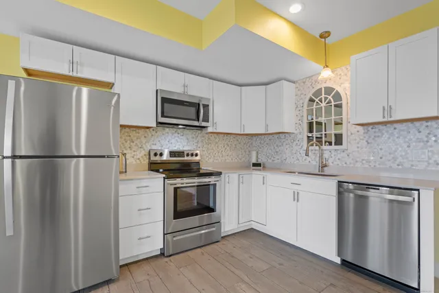 a kitchen with stainless steel appliances granite countertop a refrigerator sink and stove