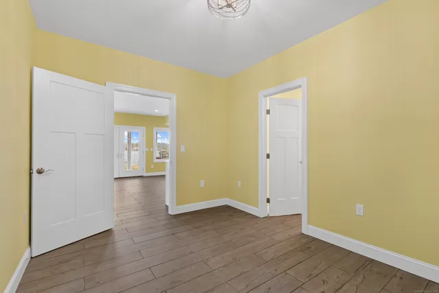 a view of an empty room with closet and wooden floor