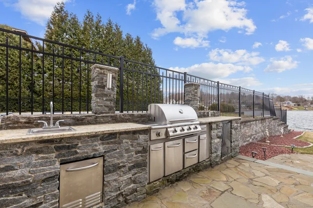 a open kitchen with a sink and stove next to a yard