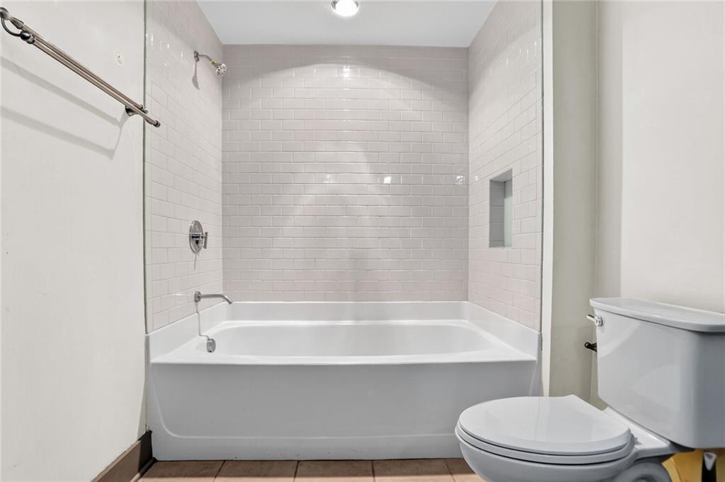 4561 Olde Perimeter Way, Unit 1207 Atlanta, GA 30346 - Photo 14 of 32 a bathroom with a bathtub and a toilet