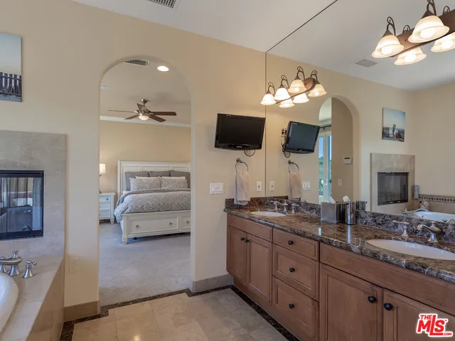 a bathroom with a toilet a sink a light fixture and a mirror