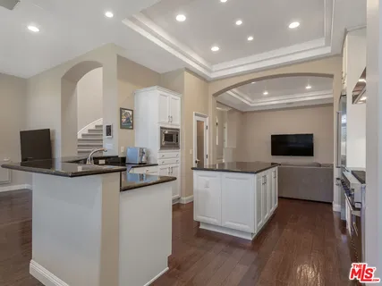 a kitchen with white cabinets and appliances
