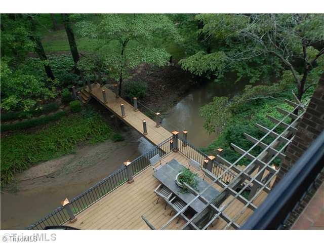 8262 Ballard Road Colfax, NC 27235 - Photo 13 of 16 Yard/Garden. Deck, backyard walkway across creek from balcony on second floor