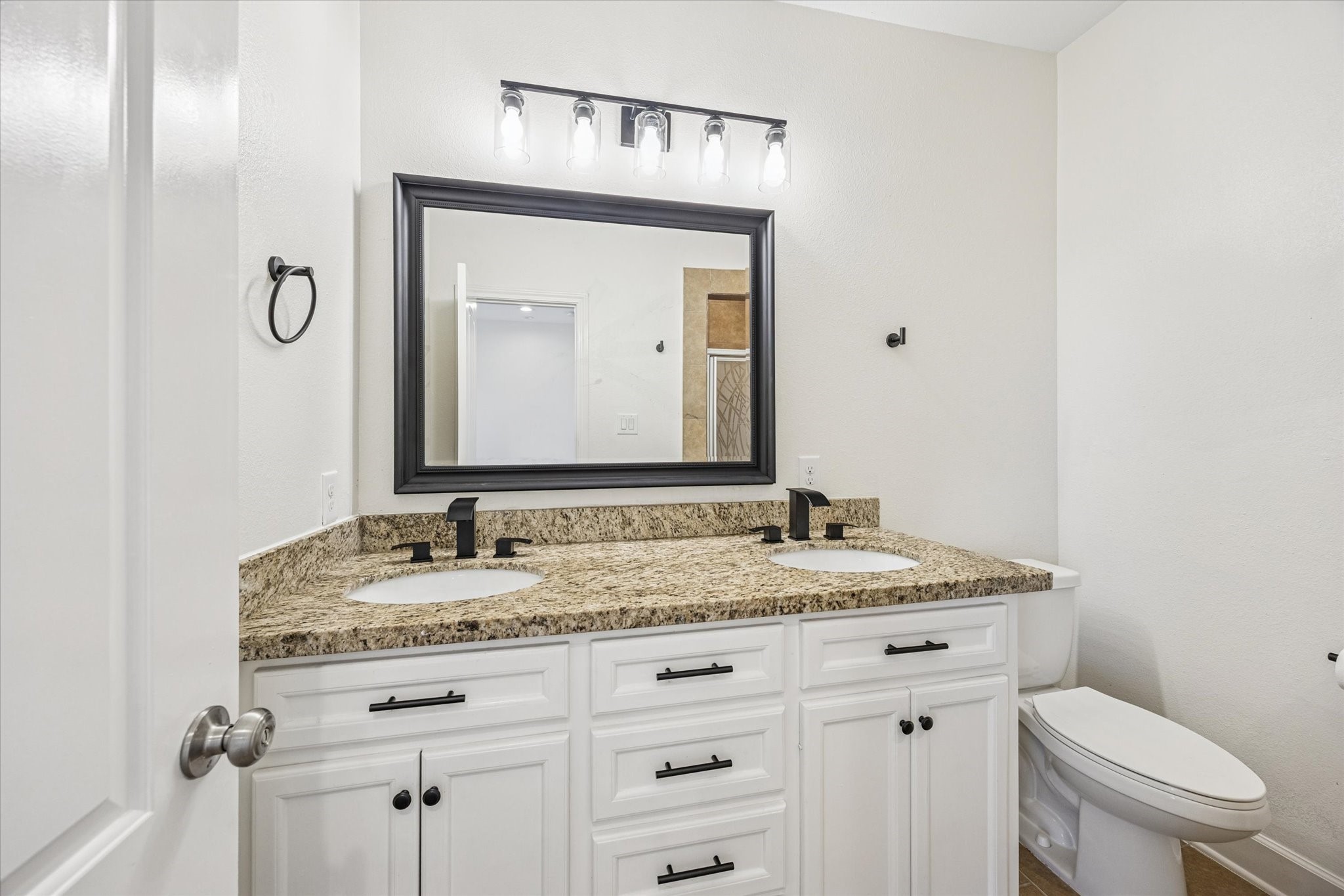 5402 Jonathan Lane Houston, TX 77011 - Photo 17 of 33 a bathroom with a granite countertop sink vanity mirror and toilet
