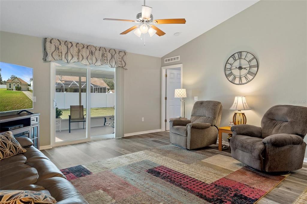 12255 Linden Drive Spring Hill, FL 34608 - Photo 12 of 26 a living room with furniture a clock and a rug