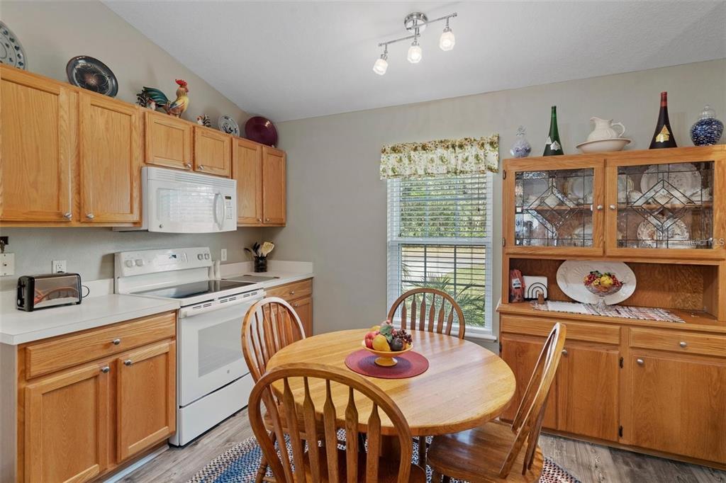 12255 Linden Drive Spring Hill, FL 34608 - Photo 6 of 26 a kitchen with stainless steel appliances granite countertop a stove top oven a sink a dining table and chairs with wooden floor