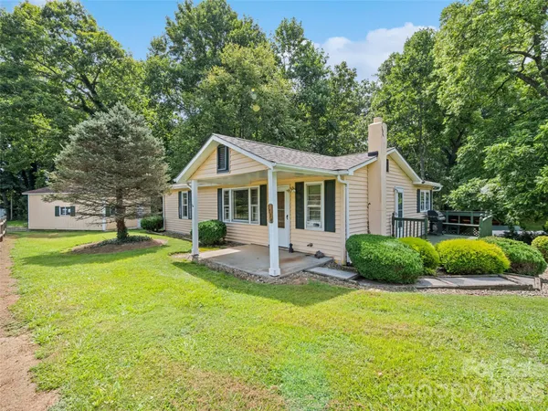a view of a house with a yard patio and swimming pool