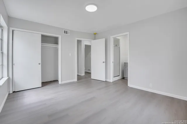 an empty room with closet and a window