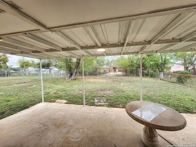 a backyard of a house with table and chairs