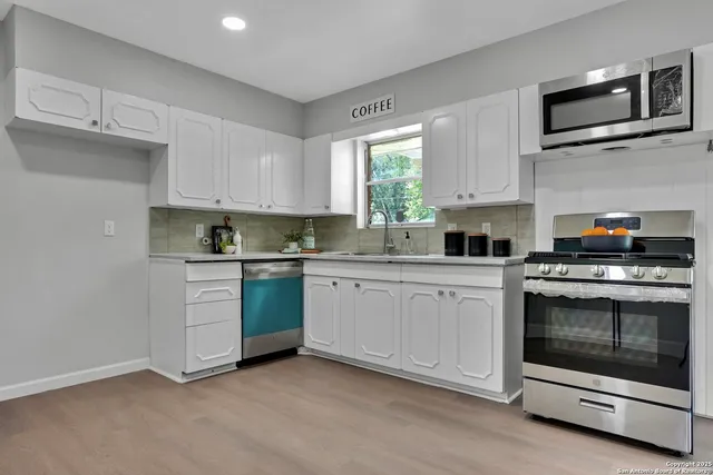 a kitchen with stainless steel appliances granite countertop a stove a sink and a microwave