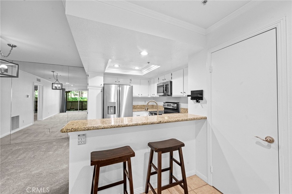 215 South Cross Creek Road, Unit L Orange, CA 92869 - Photo 34 of 50 a large white kitchen with granite countertop lots of counter top space and refrigerator