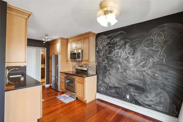 a kitchen with granite countertop a stove a sink and a refrigerator