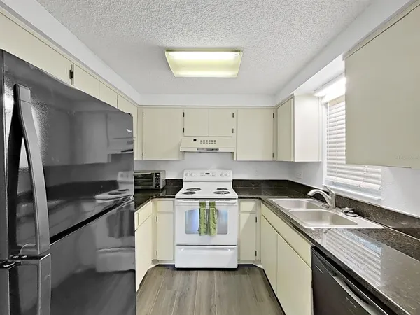 a kitchen with granite countertop a sink and cabinets