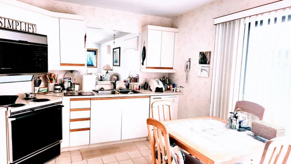 a kitchen with stainless steel appliances kitchen island granite countertop a sink stove and white cabinets