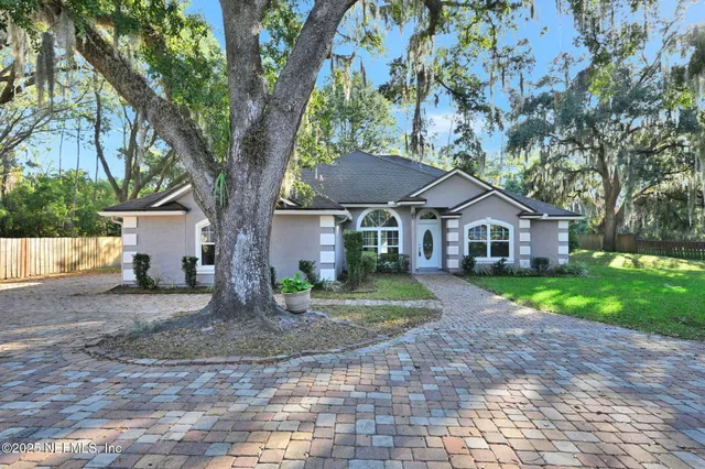 a front view of a house with a yard and trees