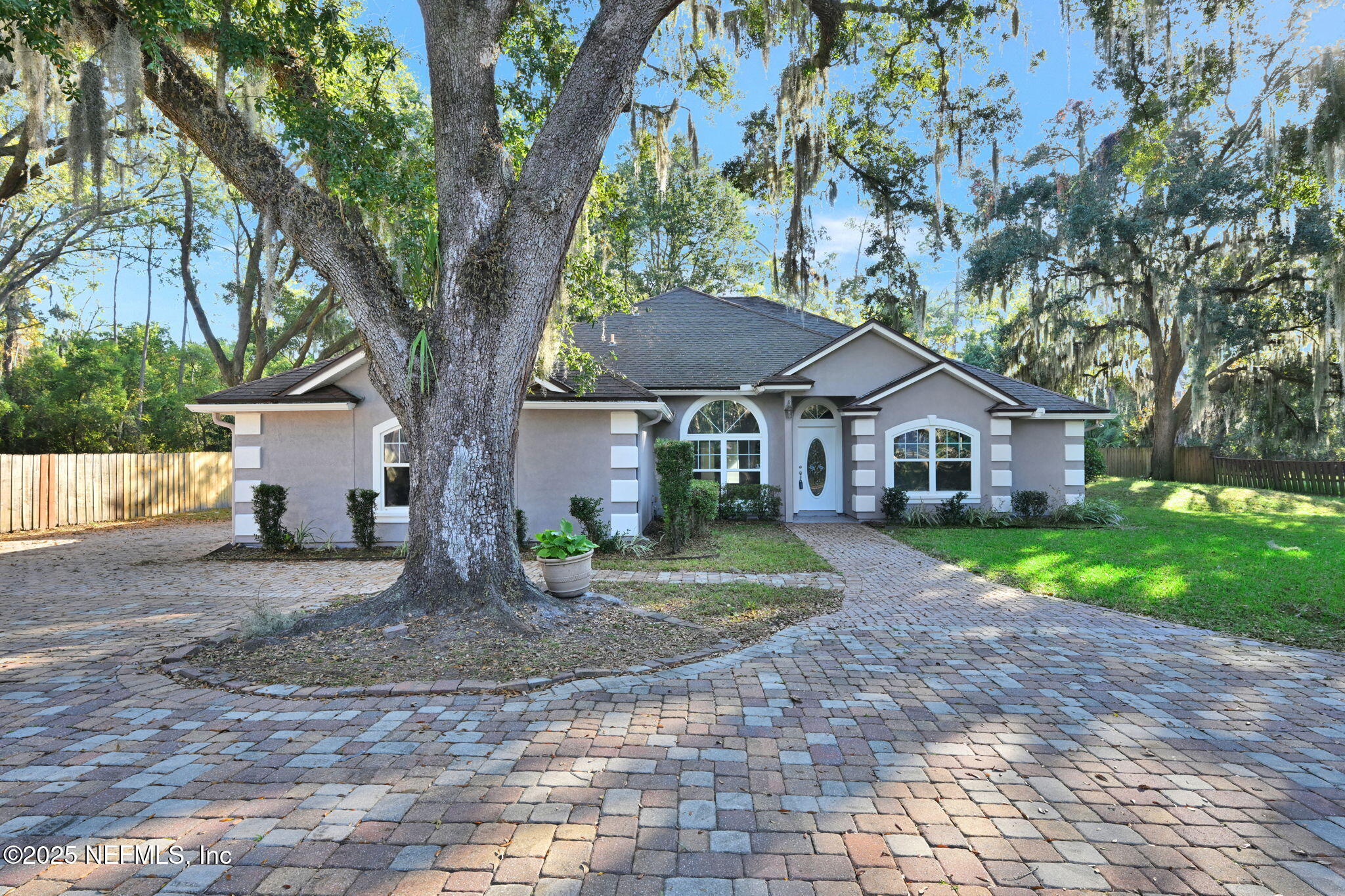 a front view of a house with a yard and trees