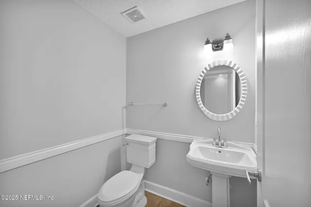 a bathroom with a toilet a sink and mirror