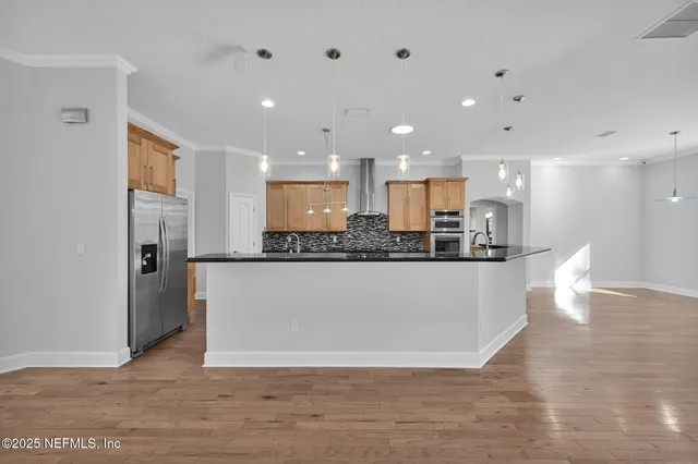 a view of a kitchen with kitchen island and stainless steel appliances