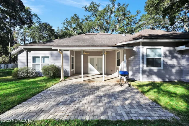 a view of a chair and table in backyard of the house