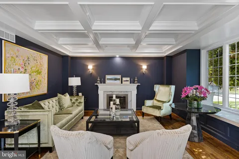 a living room with furniture a fireplace and a chandelier