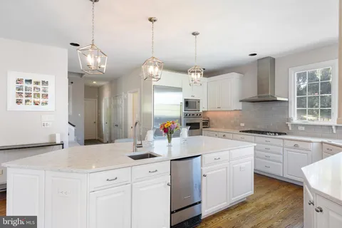 a kitchen with kitchen island white cabinets and white appliances