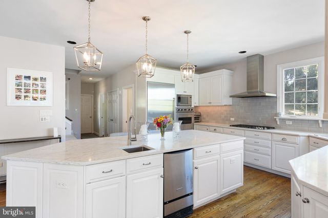 a kitchen with kitchen island white cabinets and white appliances