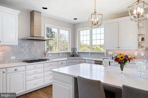 a kitchen with granite countertop a sink white cabinets and a window
