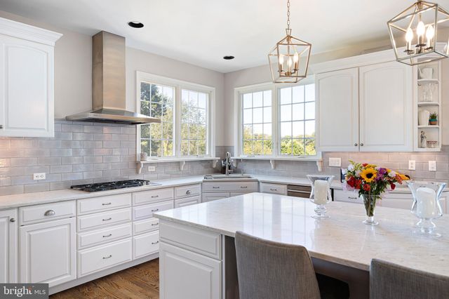 a kitchen with granite countertop a sink white cabinets and a window