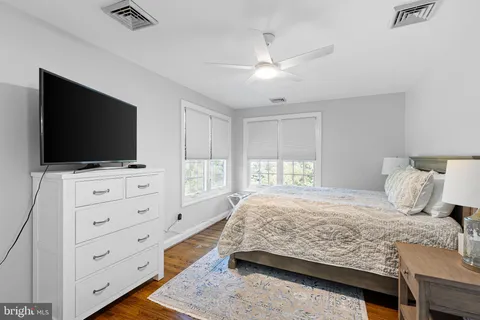 a bedroom with a bed and a flat screen tv in the dresser