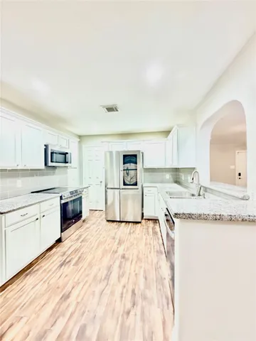 a large kitchen with a stove top oven sink and cabinets