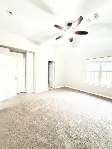 an empty room with windows and cabinet