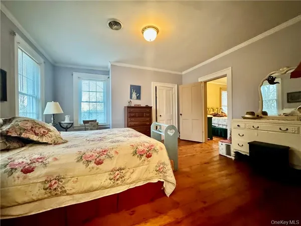 a bedroom with a bed and dresser with mirror