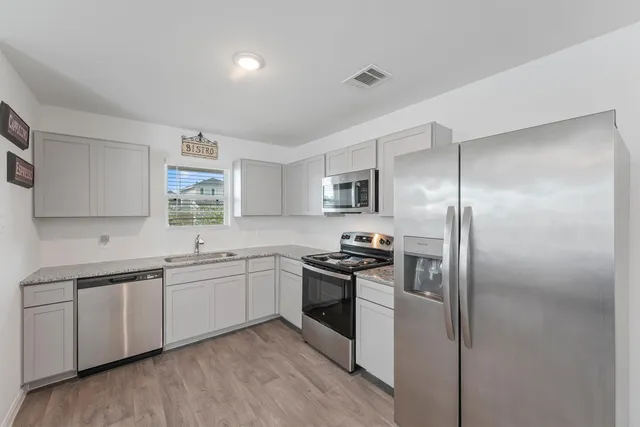 a kitchen with a sink stainless steel appliances and window