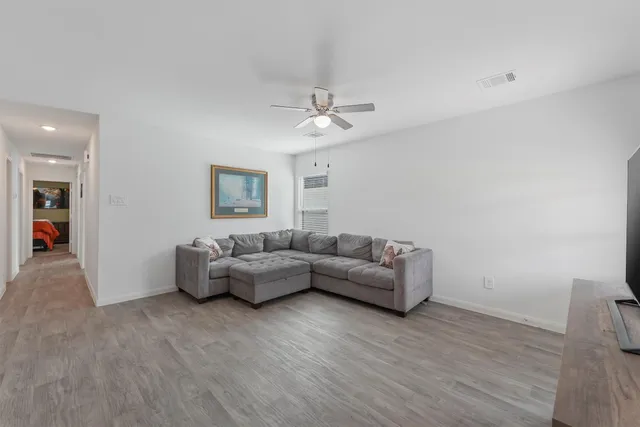a living room with furniture and a wooden floor