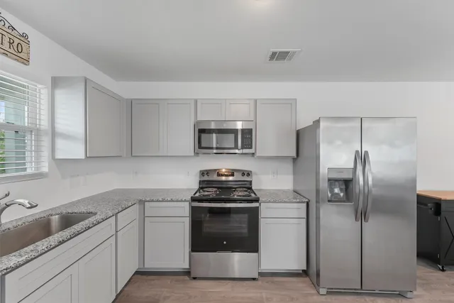 a kitchen with a refrigerator stove and sink