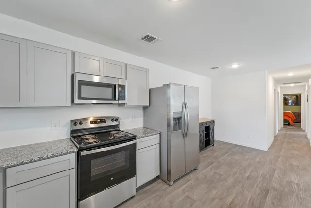 a kitchen with stainless steel appliances a refrigerator stove and microwave